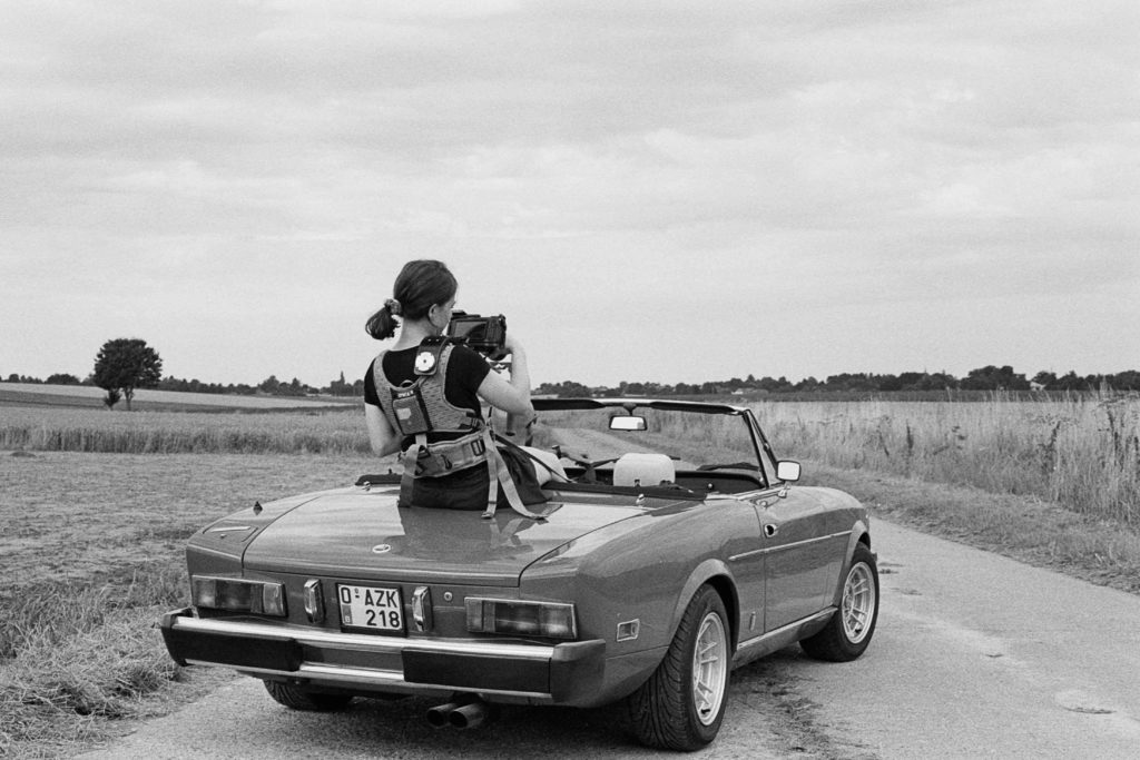 Jeune femme de dos dans une voiture cabriolet